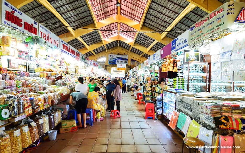 Intérieur du Ben Thanh Market, stands de nourriture, couleurs vives et ambiance animée.